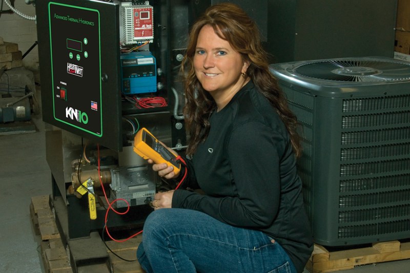 An Energy Systems Technology student monitors an HVAC device.